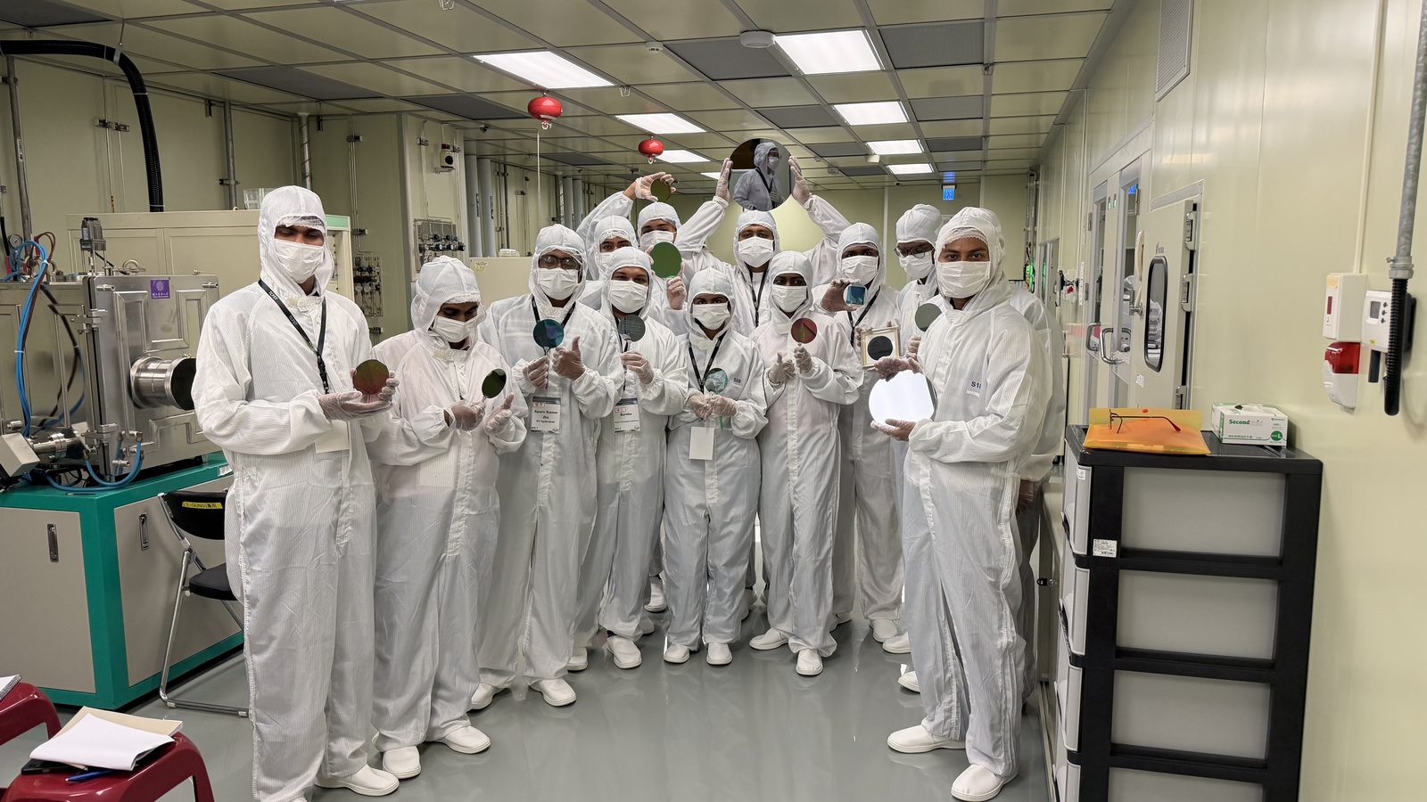 SPARC-NanoX Phase 3 participants holding processed wafers in the cleanroom